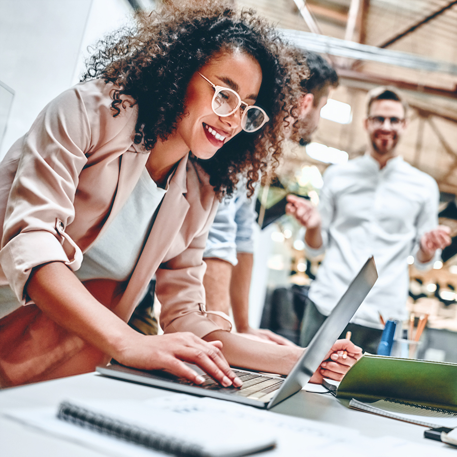 Investments team crunching numbers over laptops on a meeting table.