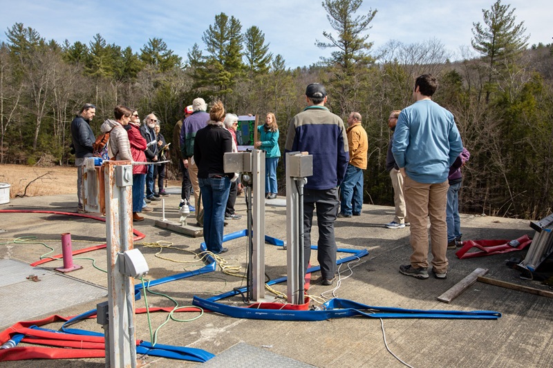 People touring the exterior of a wastewater treatment plant in a rural setting