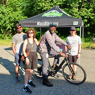 MassBike.org event, gentleman tries out a bicycle, surrounded by staff.