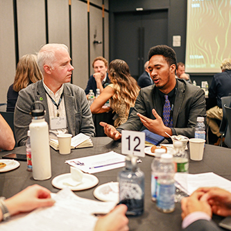 People sitting around a table at a conference.