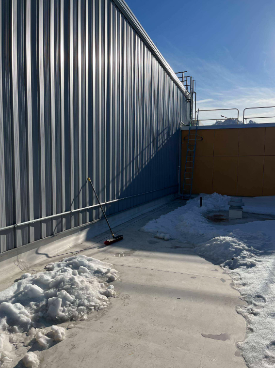 Piles of snow on roof of school.