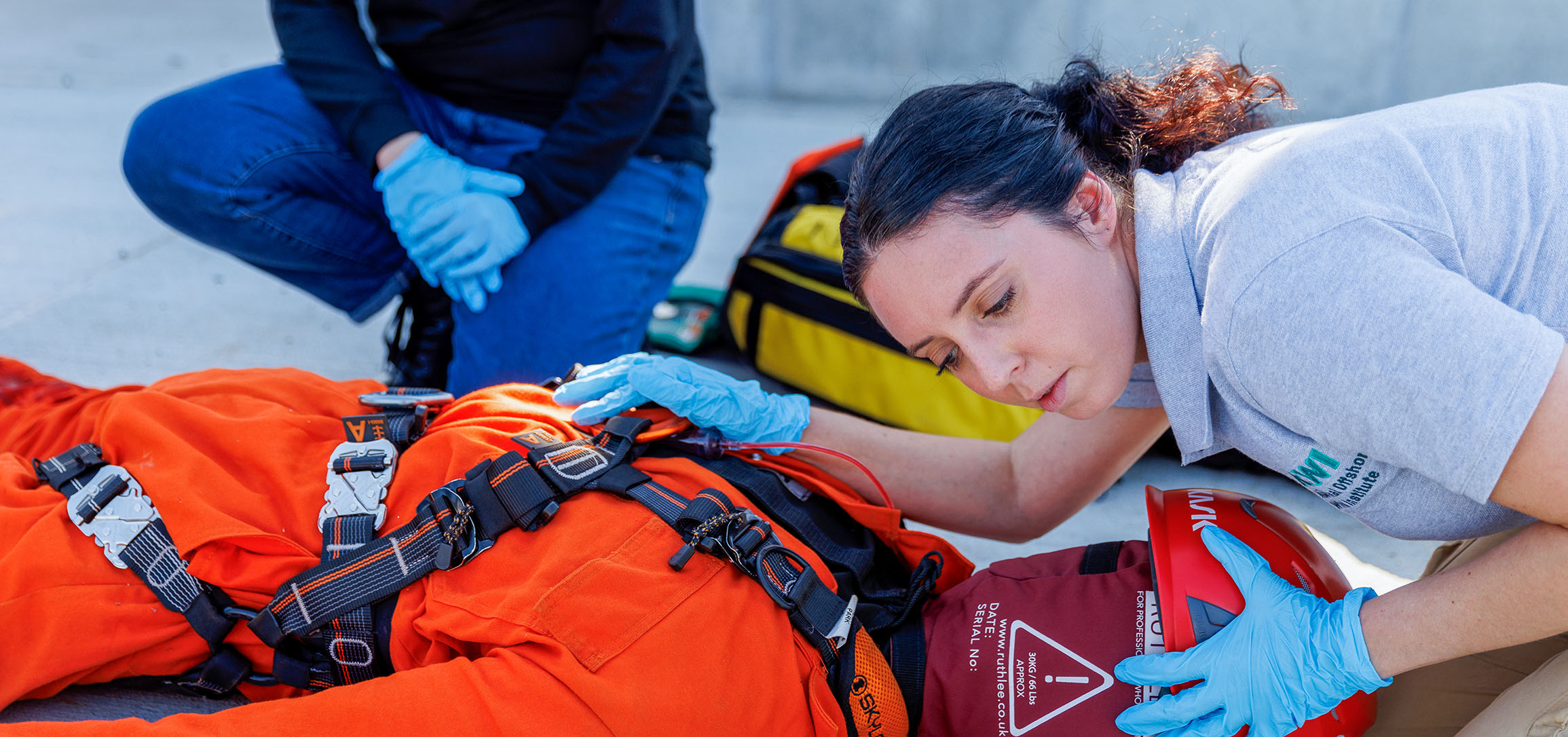 Woman in NOWI shirt demonstrates first aid on dummy