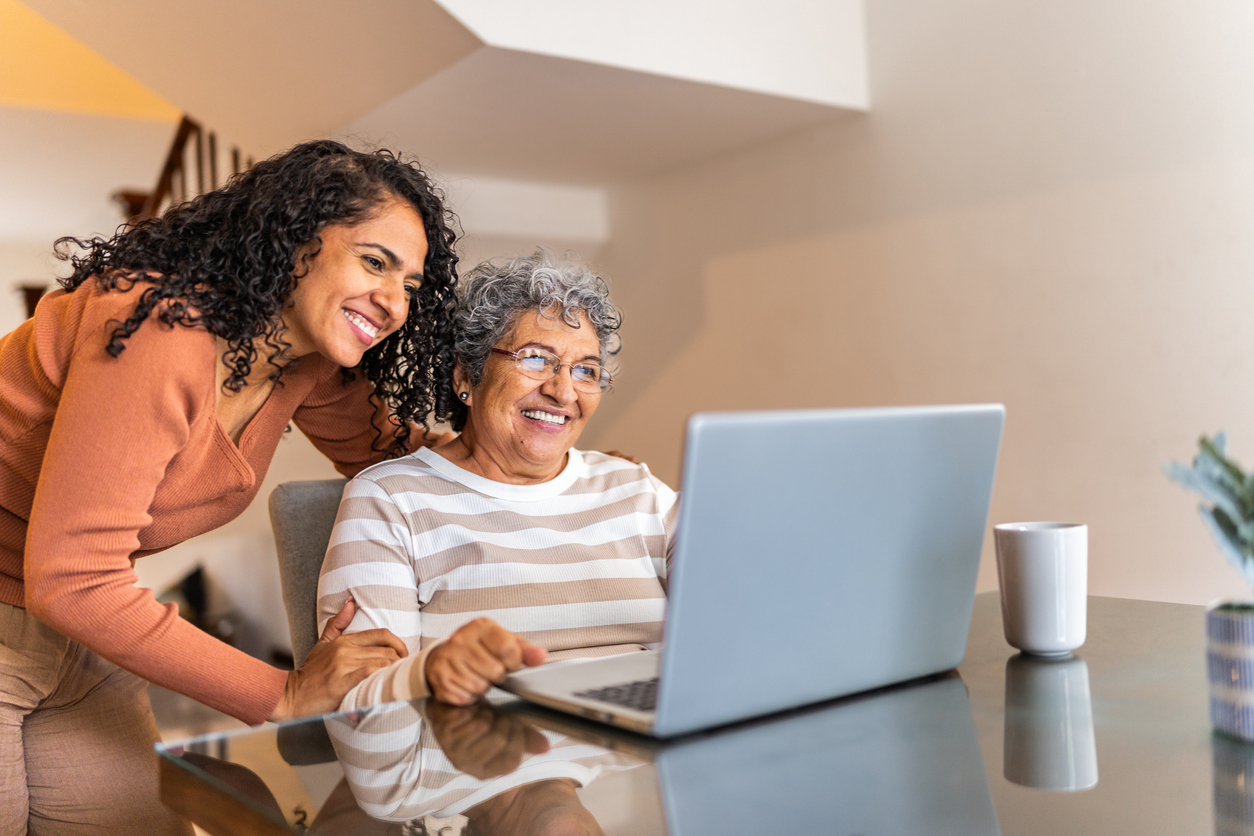 Two women looking at laptop in home setting