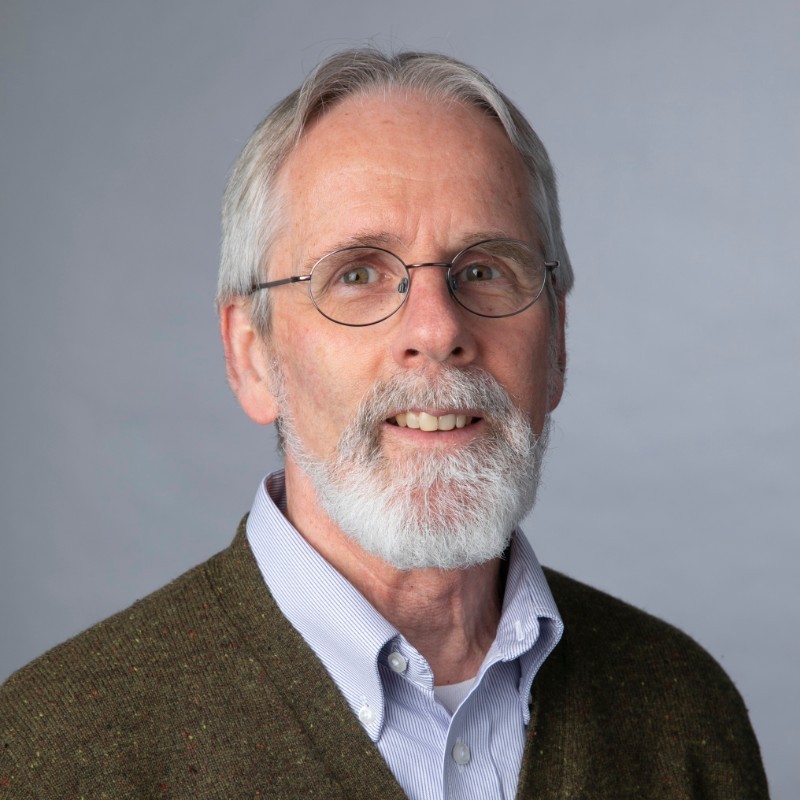 Headshot of man with trim white beard and glasses