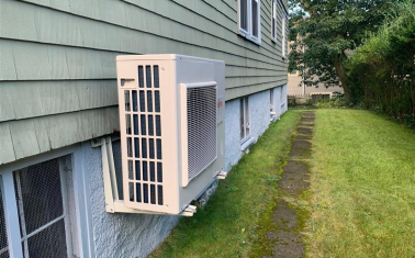 Outdoor air source heat pump unit on side of house