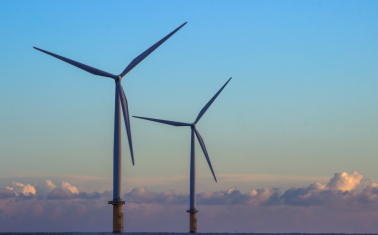 Two offshore wind turbines on an early evening