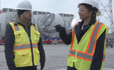 Two people in hardhats and safety vests at offshore wind terminal