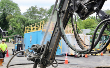 Drilling equipment installing geothermal boreholes for a district thermal energy system.