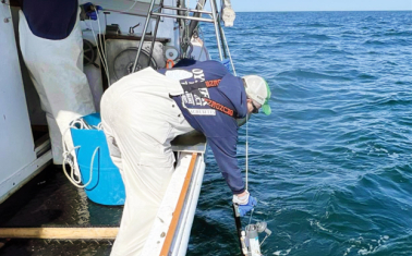 MassCEC-supported marine research team deploys ocean monitoring equipment from a boat in open water.
