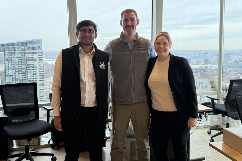 Teja Sunkari with his managers standing in front of large windows