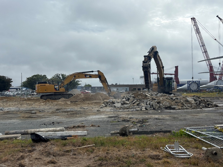 Two excavators work with debri material.