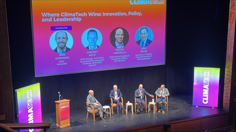 A panel of people speaking on a stage. 