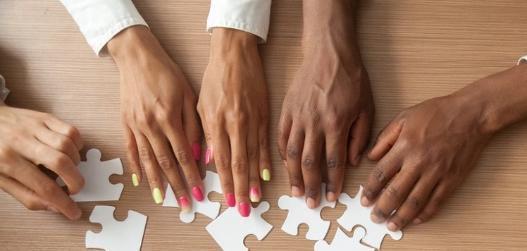 Multiple hands adjusting puzzle pieces