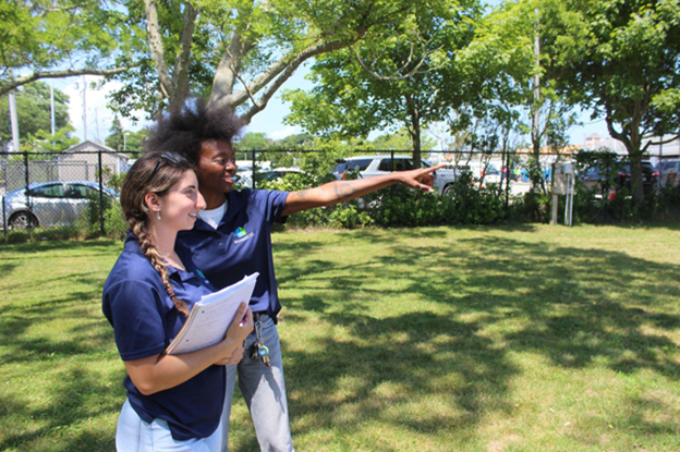Two people taking notes in a field.