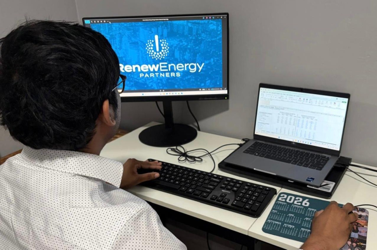 Teja Sunkari working at a desk in the Renew Energy Partners office, focused on a task during his internship.