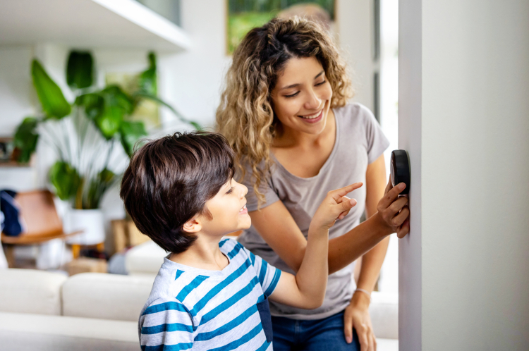 Household adjusting a smart thermostat to manage home energy use.
