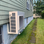 Outdoor air source heat pump unit on side of house