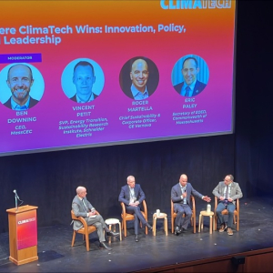A panel of people speaking on a stage. 
