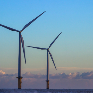 Two offshore wind turbines on an early evening