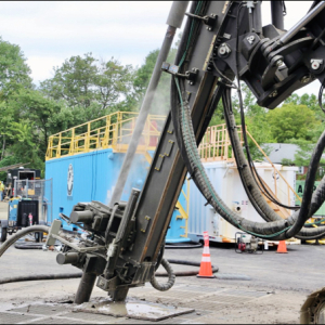 Drilling equipment installing geothermal boreholes for a district thermal energy system.