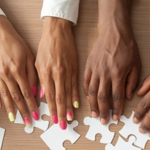 Multiple hands adjusting puzzle pieces