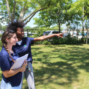 Two people taking notes in a field.