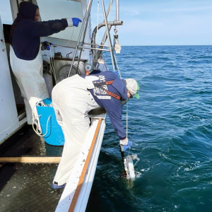 MassCEC-supported marine research team deploys ocean monitoring equipment from a boat in open water.
