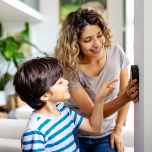 Household adjusting a smart thermostat to manage home energy use.