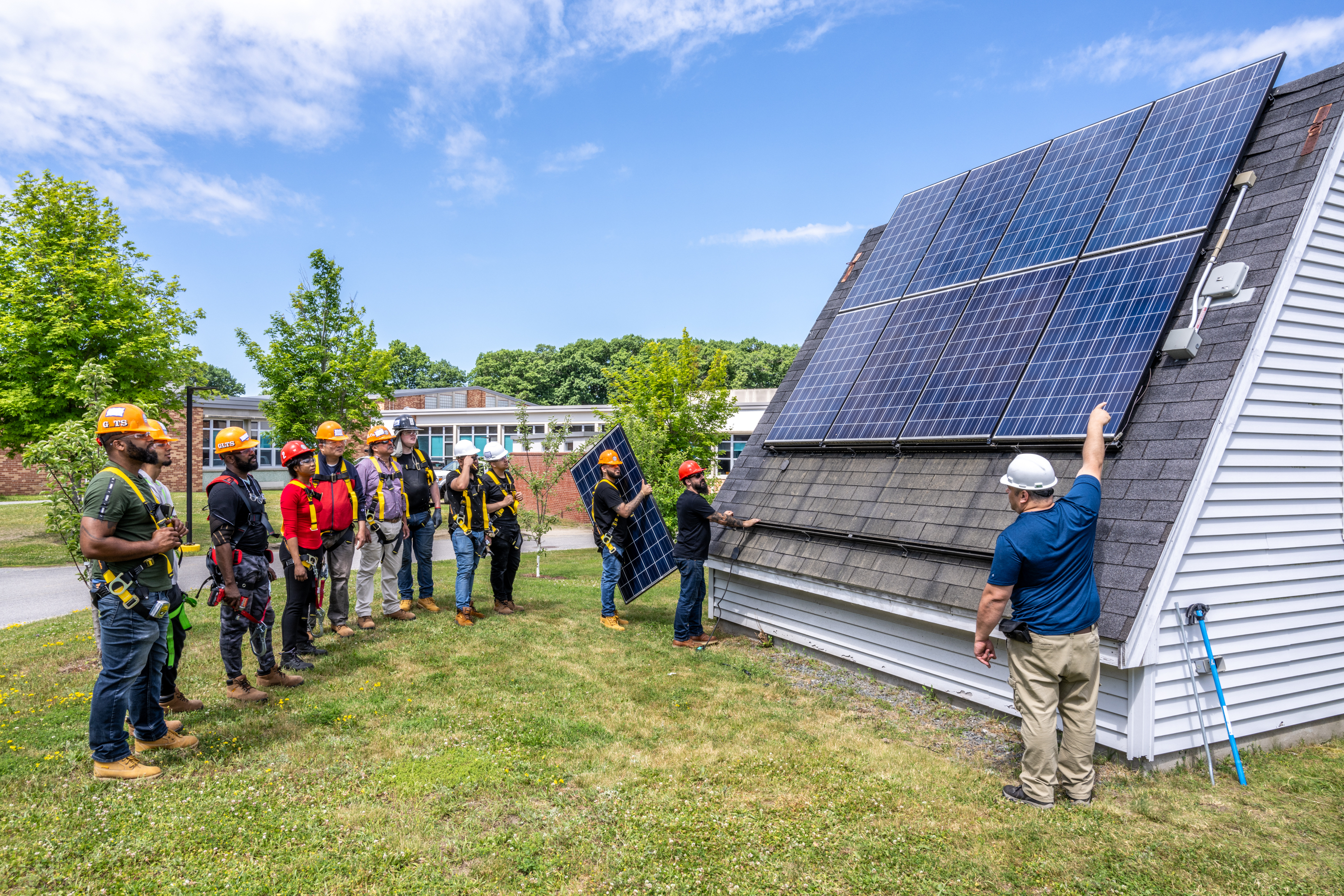 Workers outside with solar panel array Workers outside with solar panel array