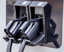 Close-up of two electric vehicle charging connectors mounted on a public EV charging station.