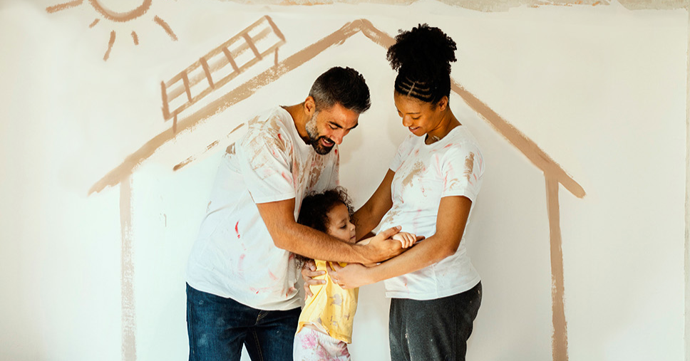 A happy family embracing while painting a room in their new home.