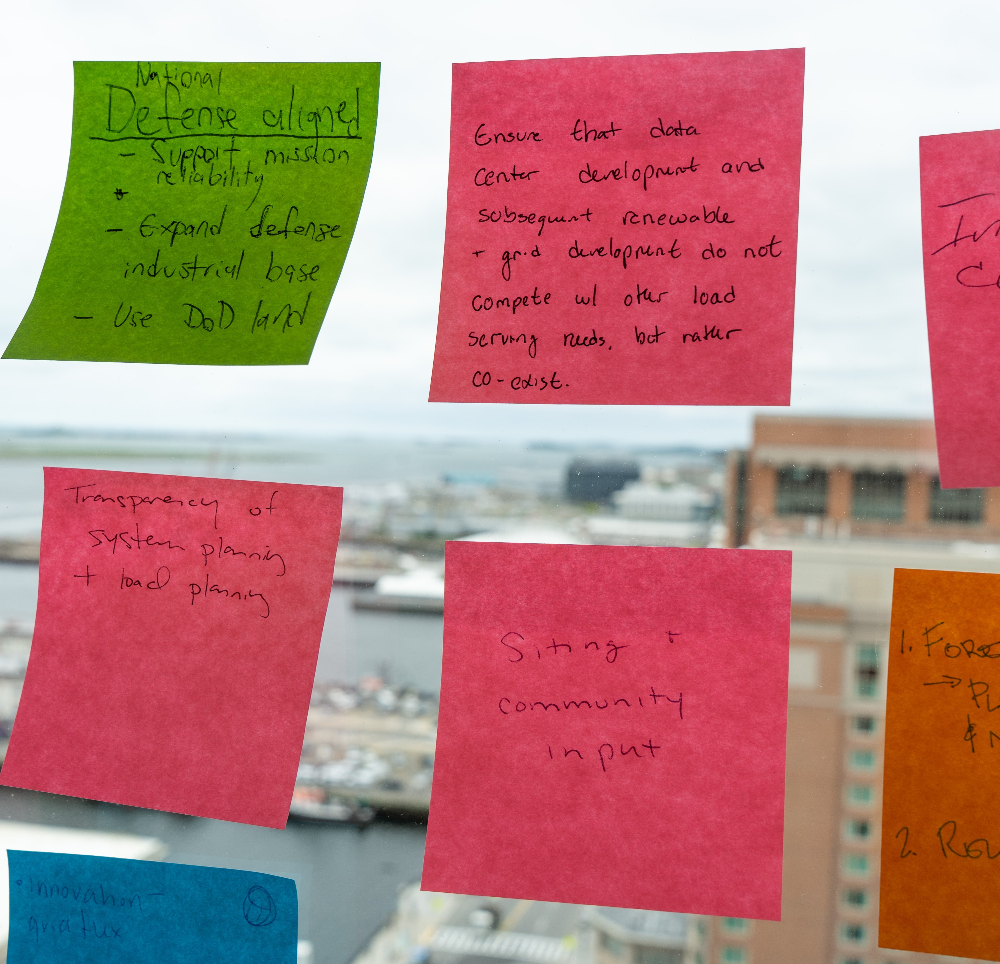 Post-it notes with writing on them stuck to the interior window of a high-rise building