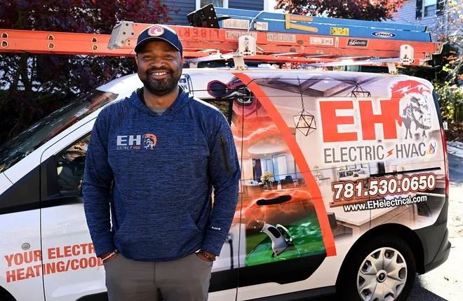 Electrical HVAC installer standing by his company van