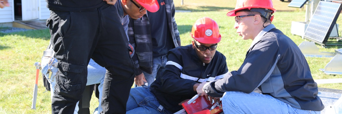 Trainer and trainees examining solar module mounting