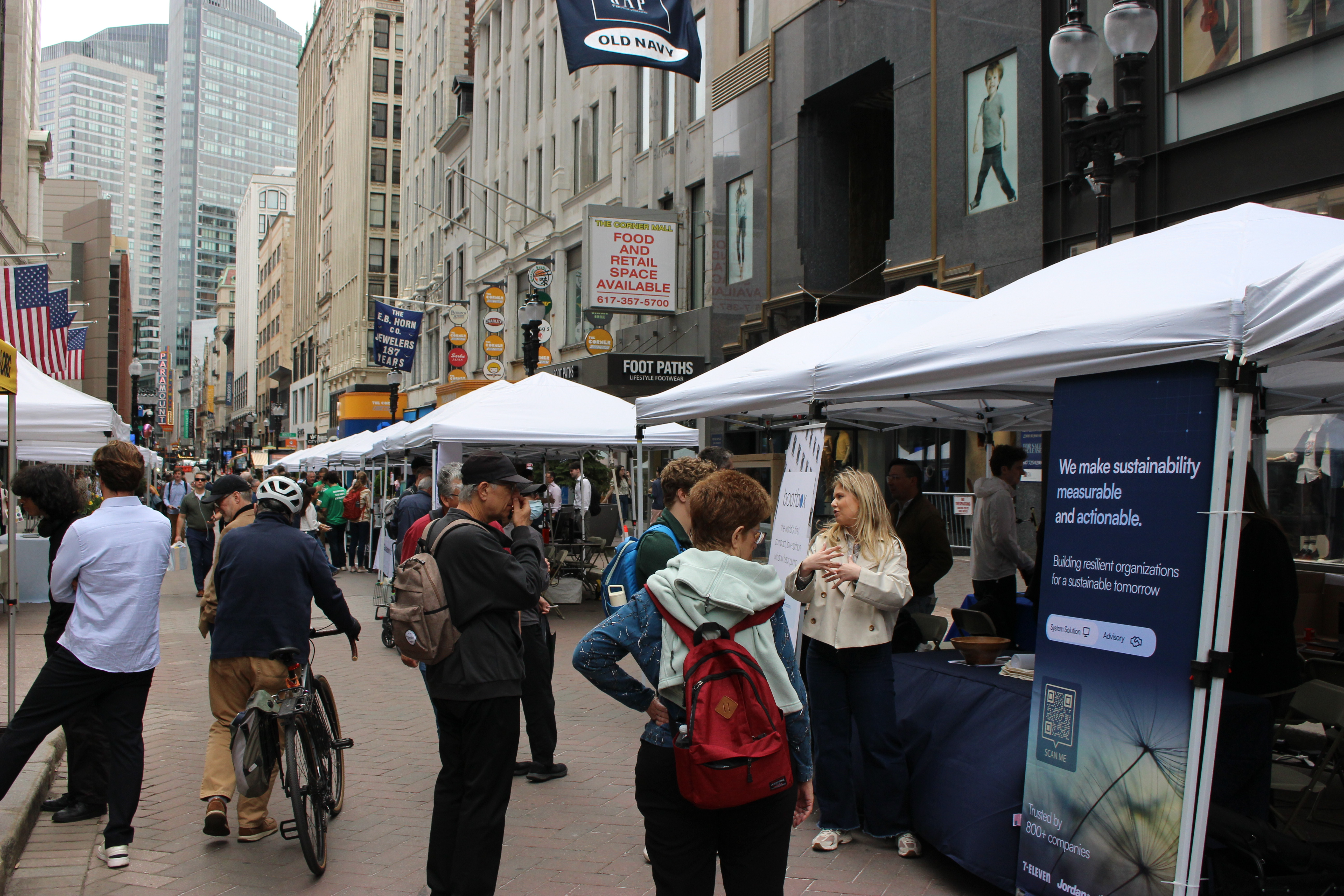 Tables and tents lined up on a busy street.