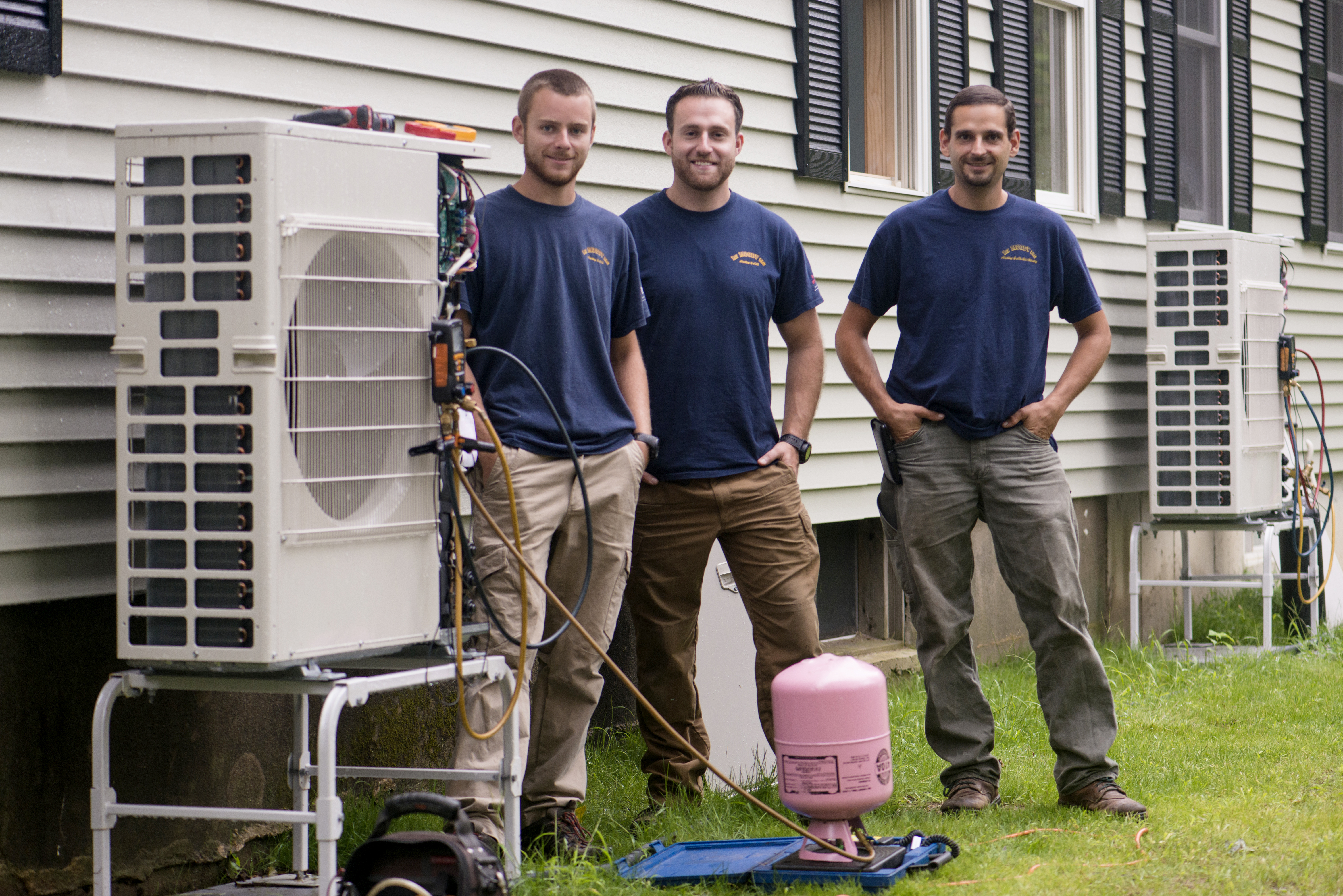 Heat pump installers outside home with heat pumps