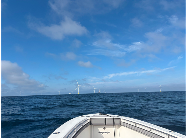 View of offshore wind farm from a boat in the ocean.