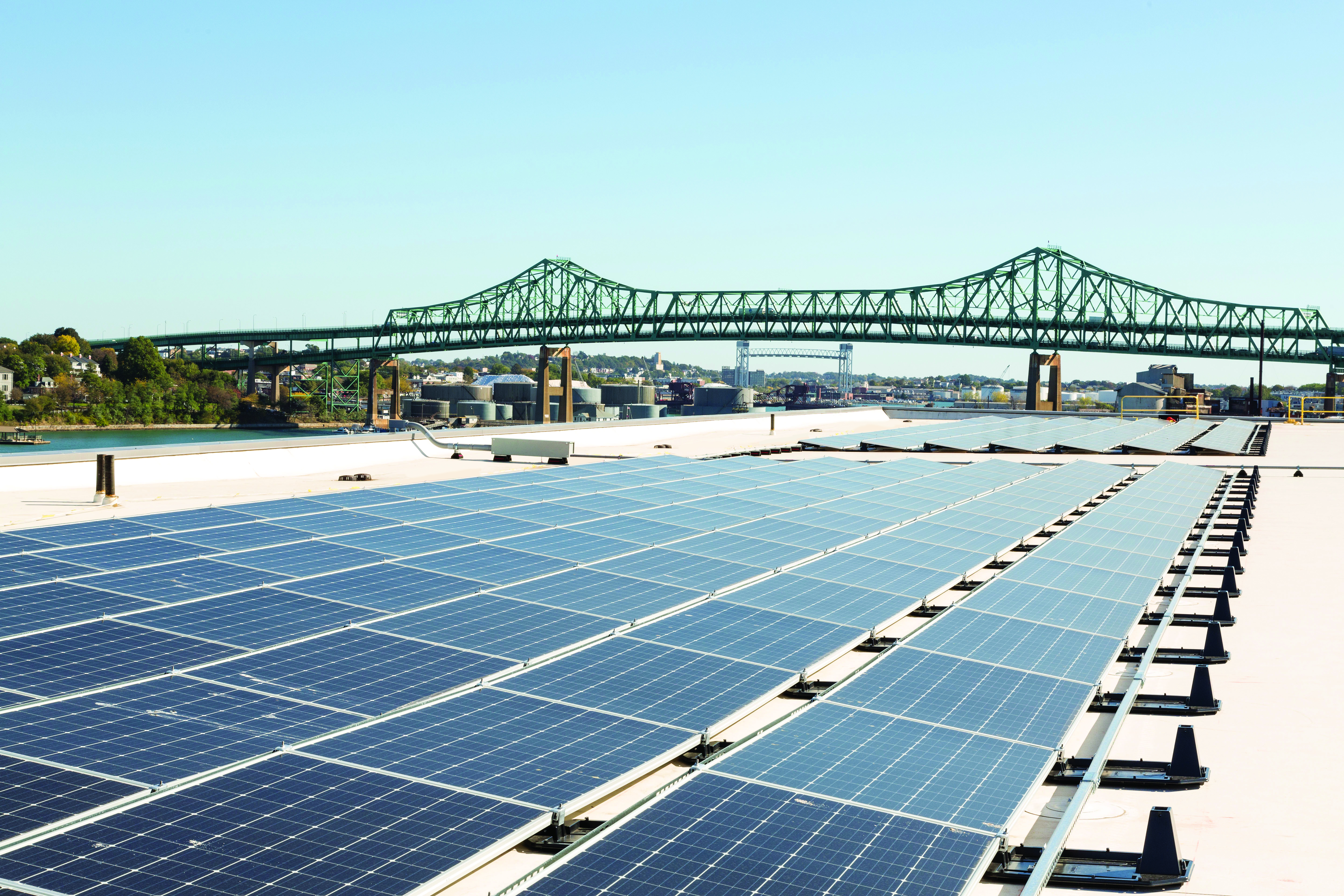 Solar panels on roof of Wind Technology Testing Center with Tobin Bridge in background
