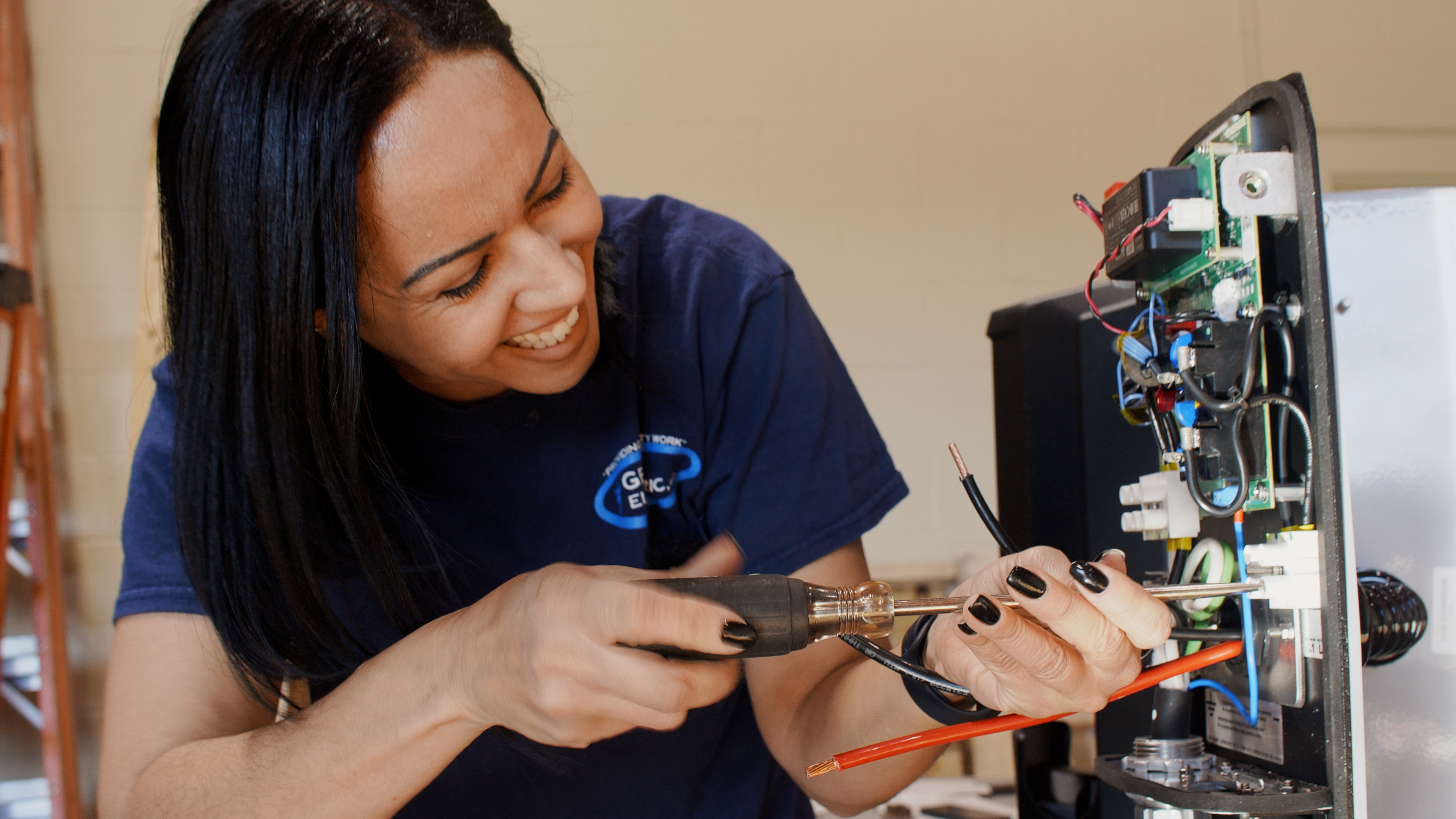 Person using a screwdriver to assemble and test electronic equipment, representing climate technology innovation and commercialization supported through MassCEC's Climatetech Pathmaker Grants.