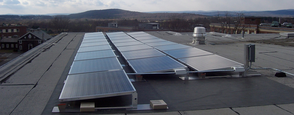 Solar panels on commercial roof with hills in background