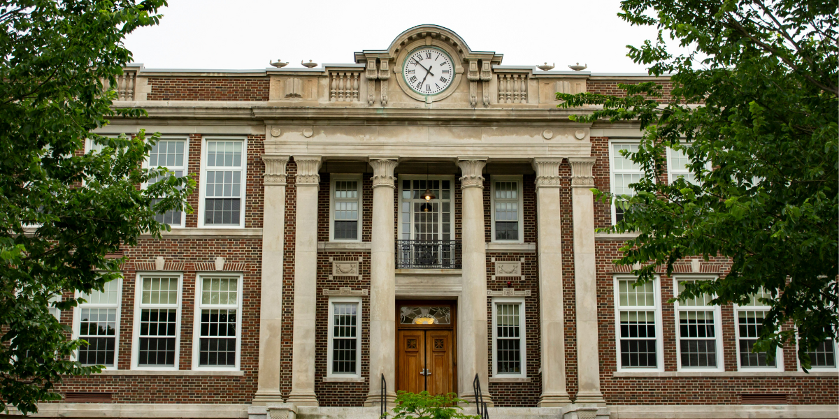 A brick school with trees around it