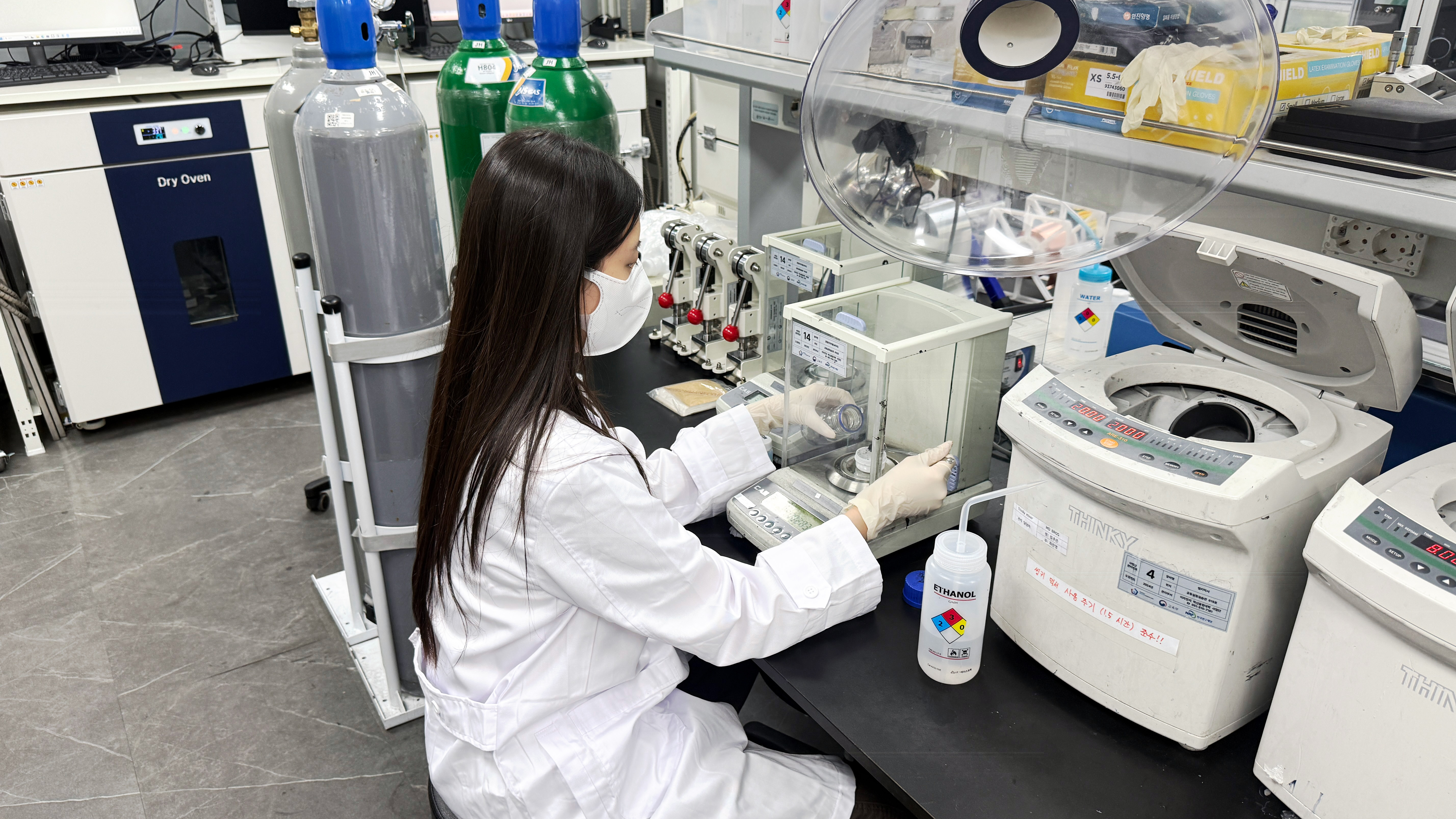 Research staff member at HGK Energy measures and prepares materials in a laboratory, supporting clean energy technology development as an InnovateMass awardee.