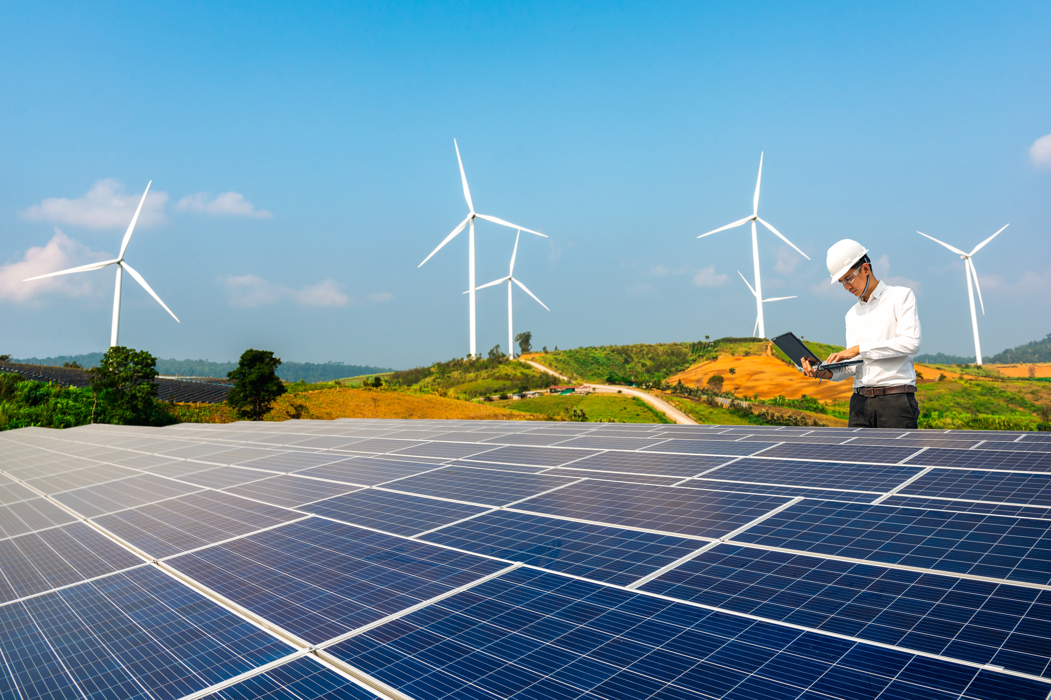 Man near solar and wind farm