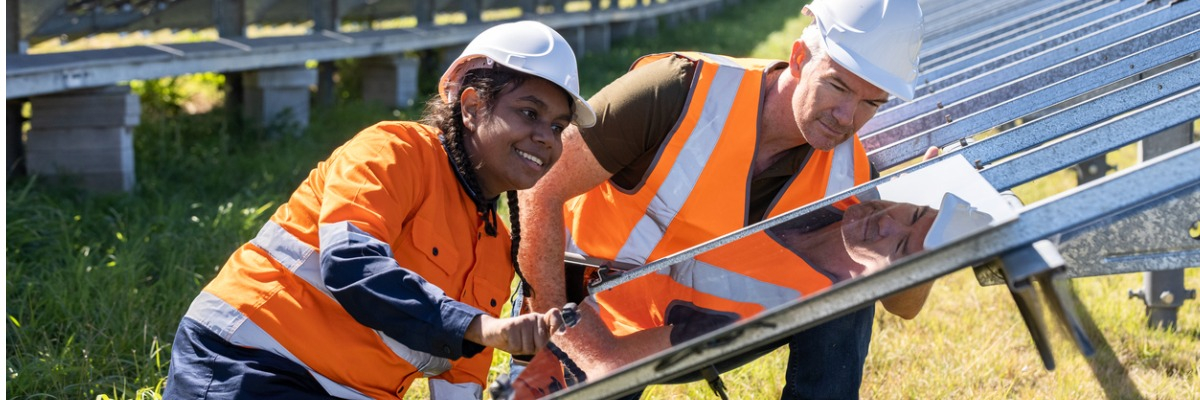 Engineer and apprentice working together on solar farm