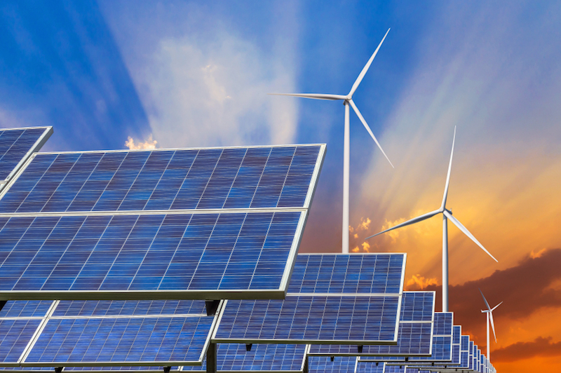 Solar panels and wind turbines against stormy sky